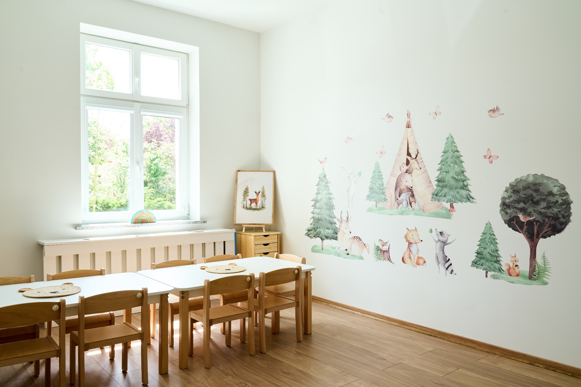 Sala Zajęć Kreatywnych w Mini Smyki — stoliki, krzesełka i akwarelowe dekoracje leśnych zwierząt na ścianie